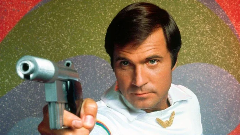 Gil Gerard as Buck Rogers, pointing a ray gun.