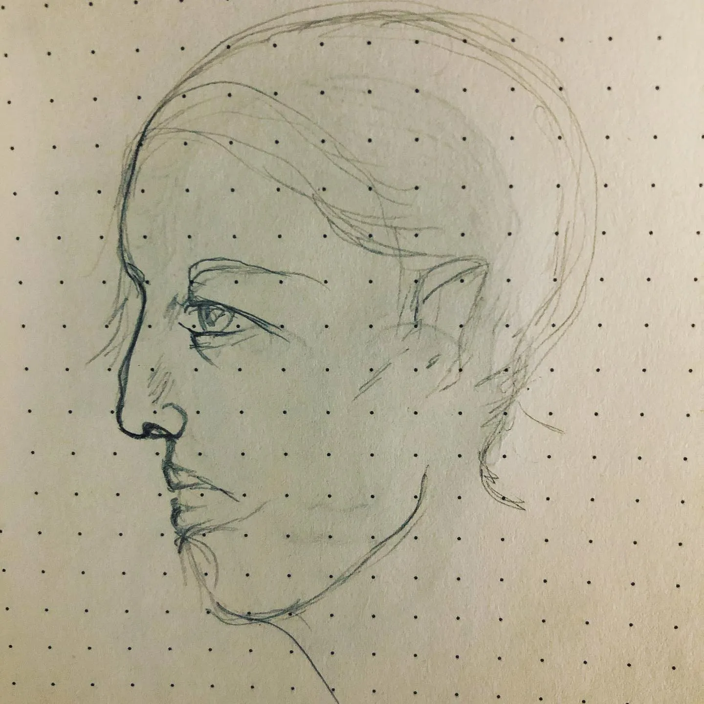 Faint pencil sketch of a figure in profile with a pointed elf ear and swept-back hair, on green-tinted paper.