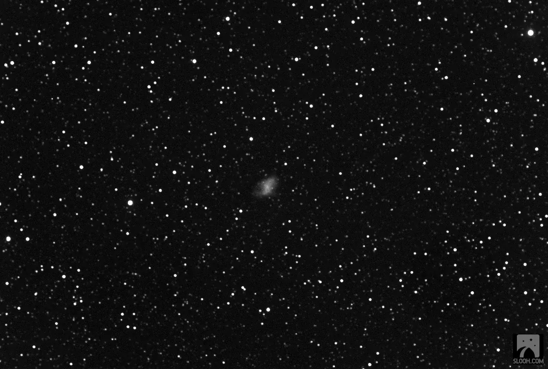 A wider field of stars with the Crab Nebula as a small grey smudge near the centre.