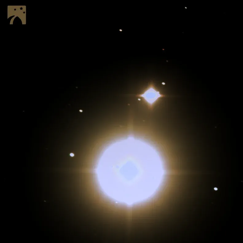 The Great Conjunction in colour: Jupiter glowing pale blue, Saturn a small bright point just above it, and two of Jupiter's moons.